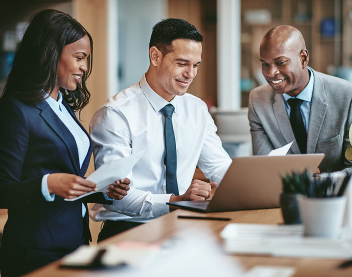 Group of people smiling as they work in an office