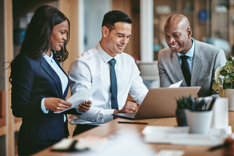 Group of people smiling as they work in an office